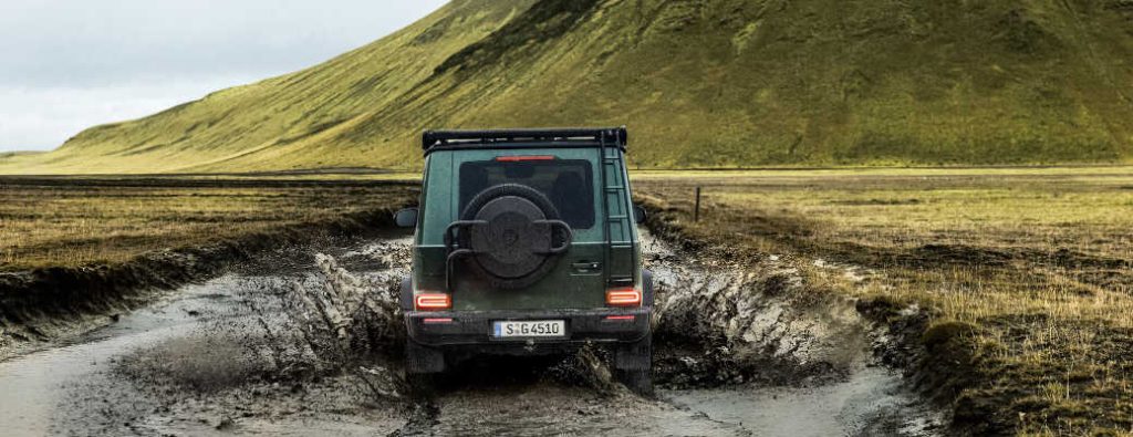 A Mercedes-Benz G-Wagen displaying its off-roading capabilities in extremely muddy conditions