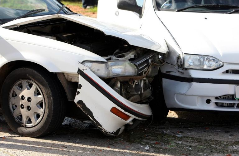 Collision of two white cars is shown.