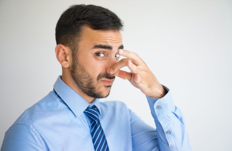 a man reacting to bad smell