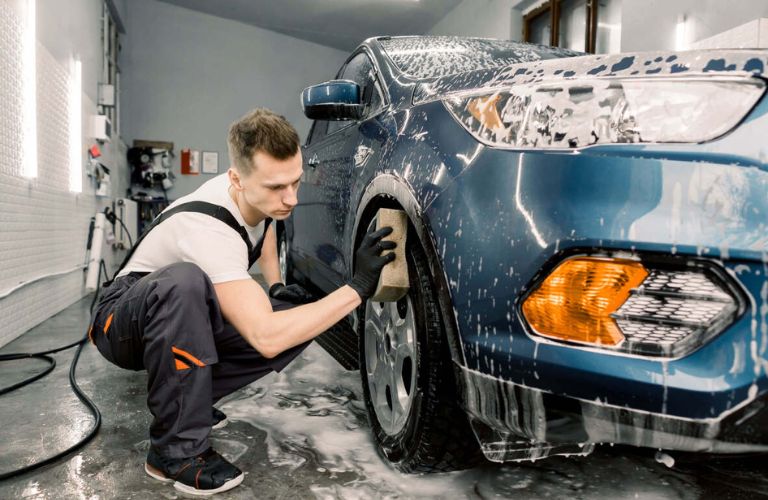 technician cleaning the tire of a car