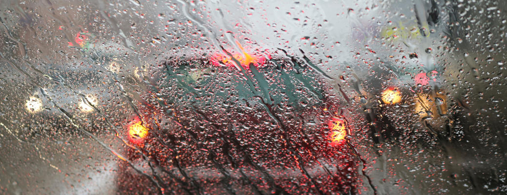 View from the car windscreen during rain and wet snow. Poor visibility while driving around the city. Snowy road.