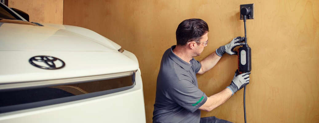 A man installing a new Toyota home charging system
