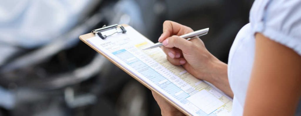 A woman using a checklist to go over items pertaining to used Toyotas with CARFAX reports