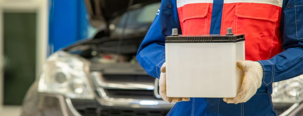Mechanic holding the car's battery