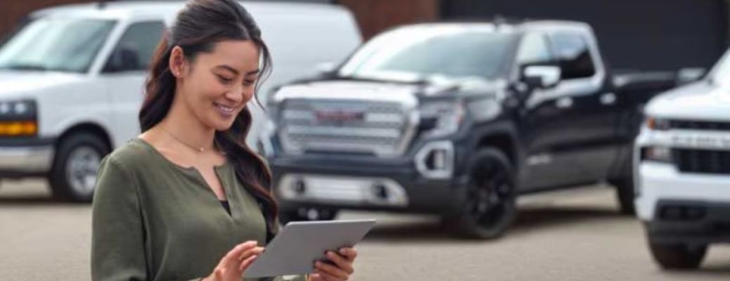 a person at a dealership holding a tablet