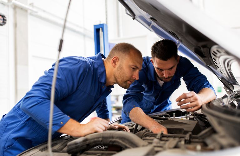 two mechanics checking the engine