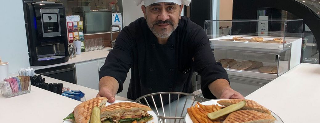 a chef holding two plates with food at Boxenstopp restaurant