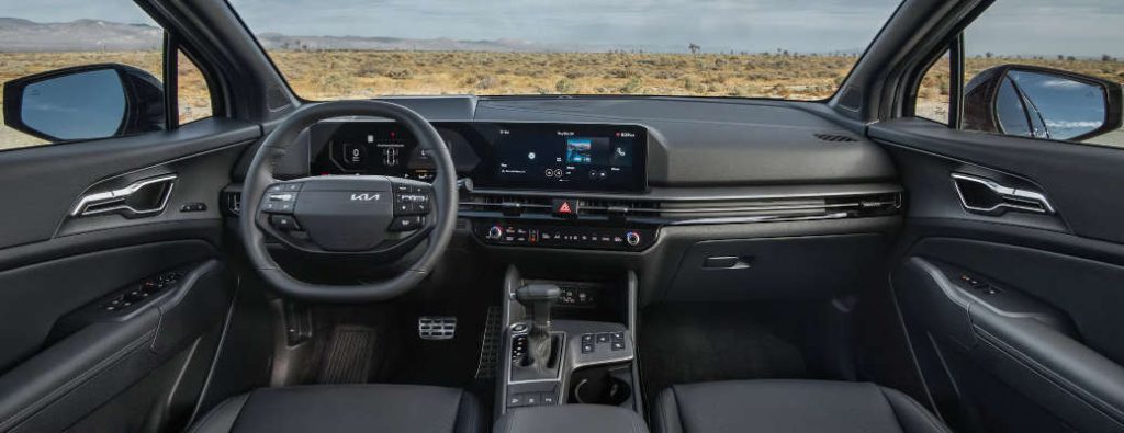 The interior tech features of the 2026 Kia Sportage, including the widescreen infotainment system and wireless charging station.