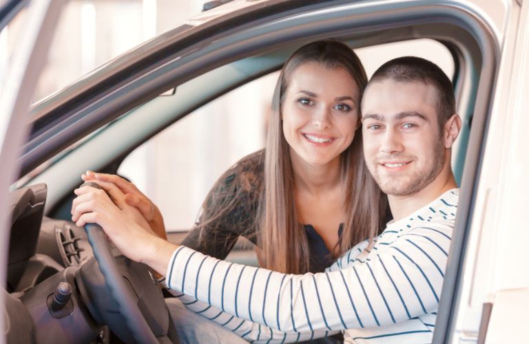 a man and woman in front seats of a car