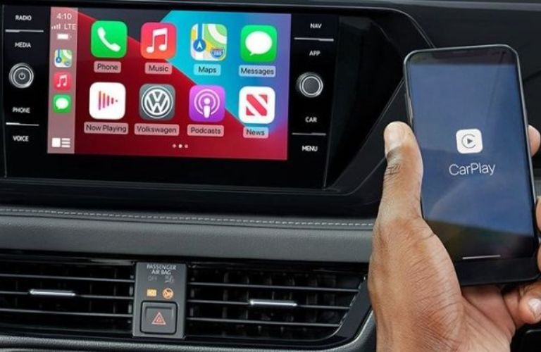 a hand connecting Apple CarPlay in a car