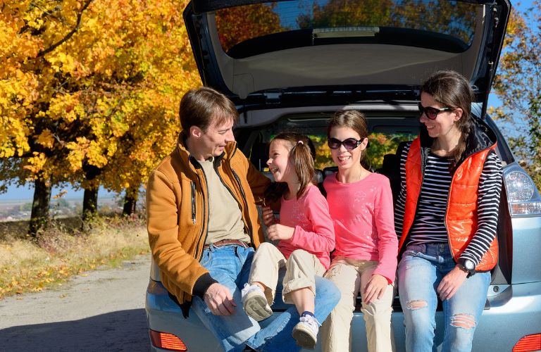 a family sitting it car's cargo area