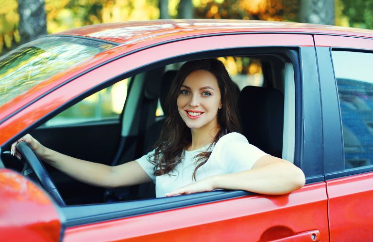 a woman smiling in driving seat