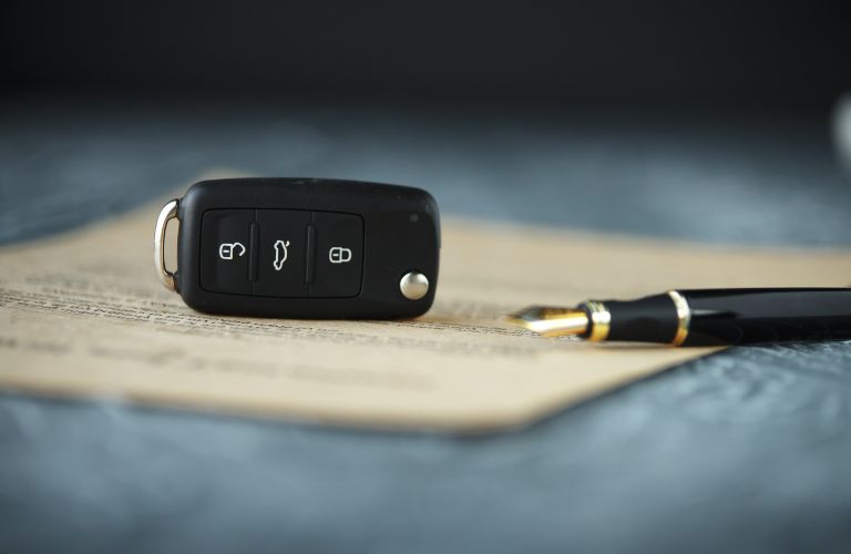 a car key and pen on a document