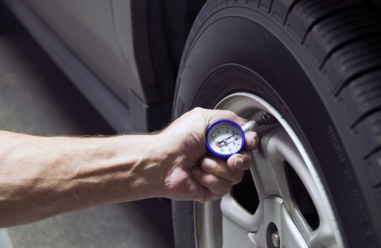 technician checking tire pressure of a tire