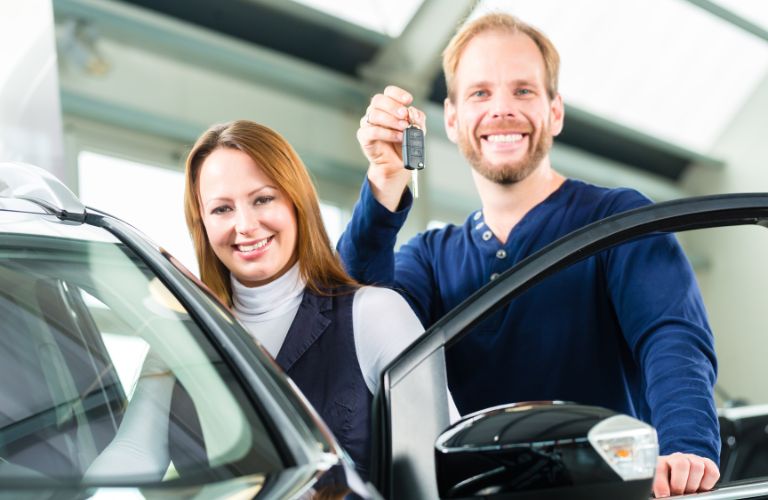 a man and woman getting inside a car