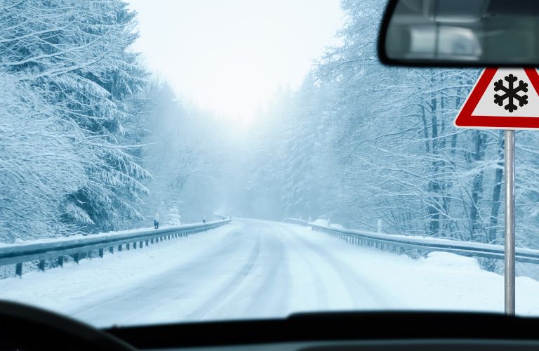 image of a snowy road from a car's windshield