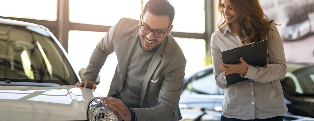 a man and woman inspecting a car