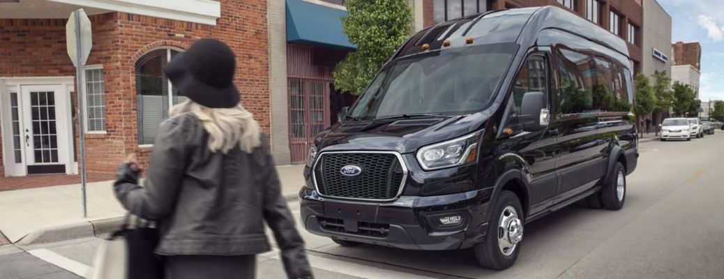 a woman crossing the road while a Ford waits on the road
