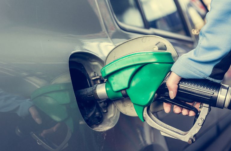 image of a hand putting fuel in a car