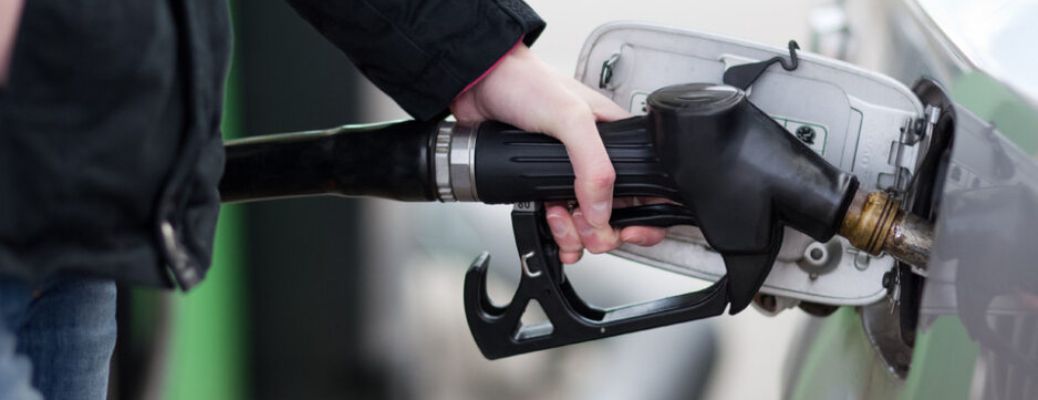 image of a hand putting fuel in a car