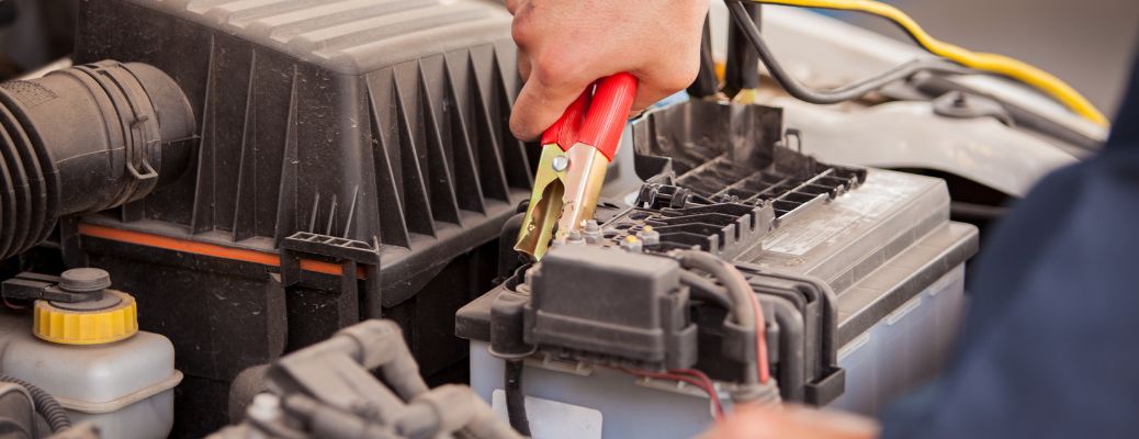 a technician jump starting a battery