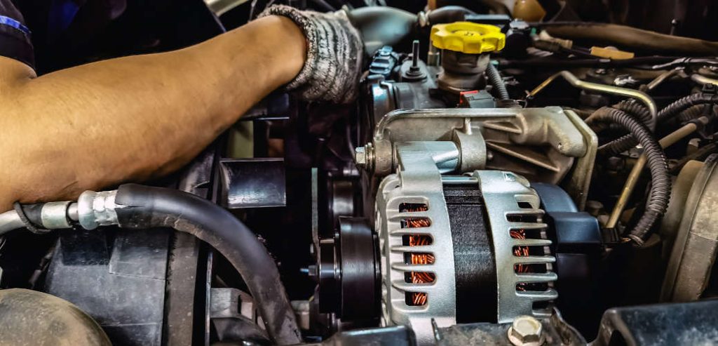 A mechanic working on a pickup truck diesel engine