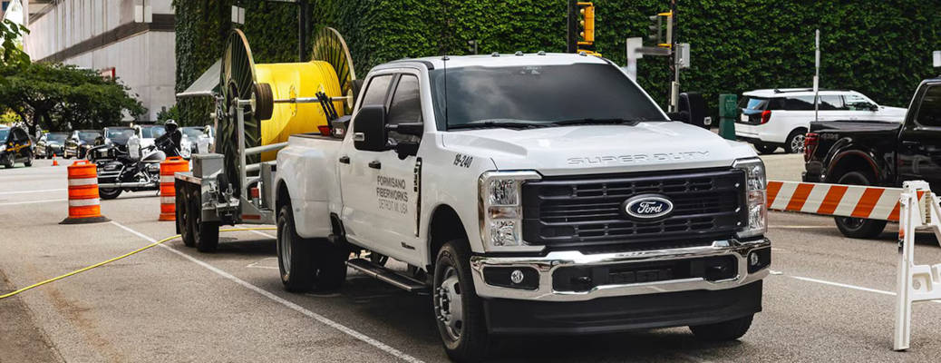 A GMC pickup truck being used in a commercial capacity to tow a large cable spool