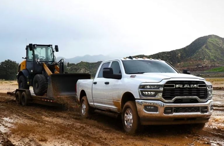 Ram 2500 towing heavy machinery in muddy terrain