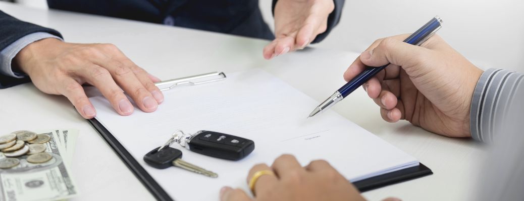 Individual signing papers with a sales representative