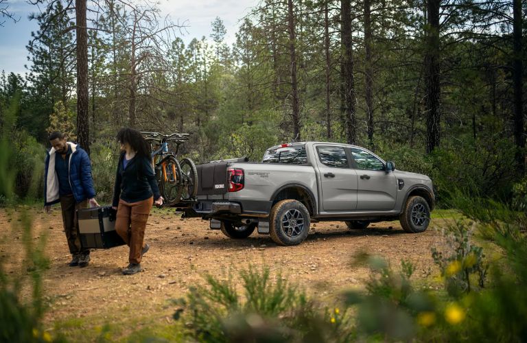 A cycle loaded on a Ford Ranger as a family enjoys a picnic in the woods