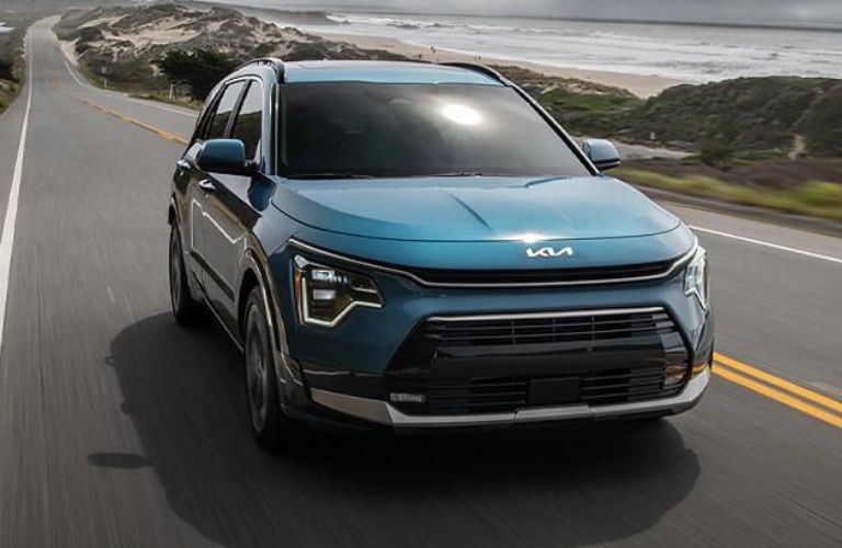 One blue color 2023 Kia Niro is running on the road.