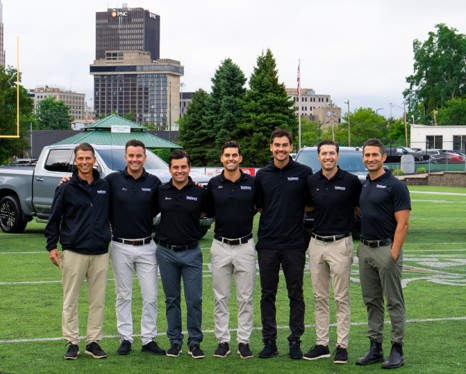 Seven Vandevere Kia employees in a football field