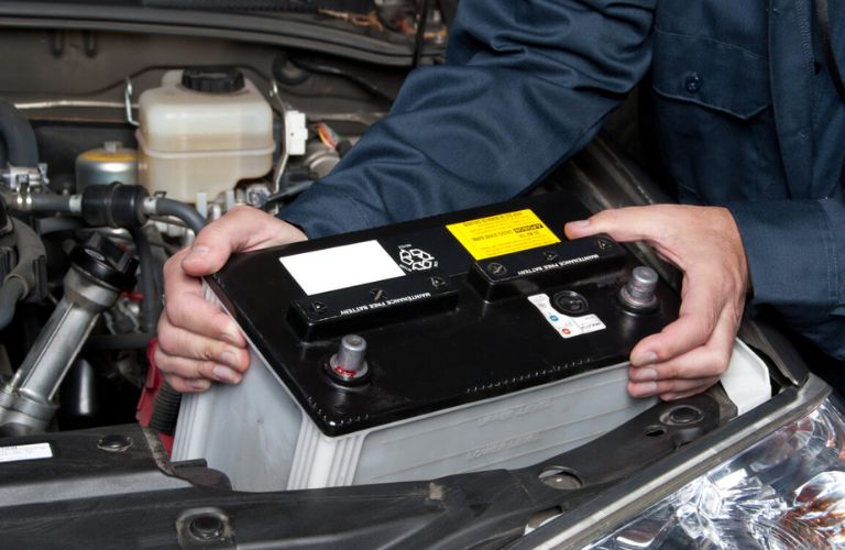 A technician placing a new battery into the slot