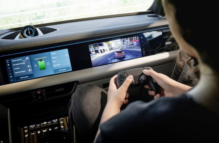 A boy playing on the infotainment display of the 2026 Porsche Macan Electric
