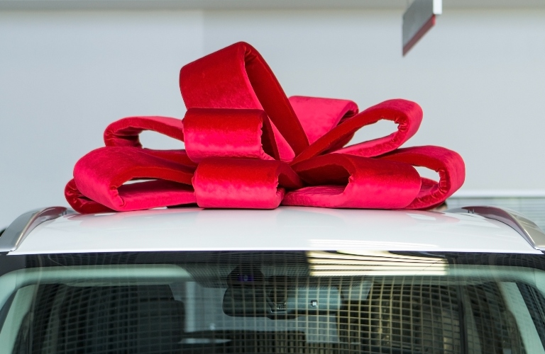 Red bow on top of a car