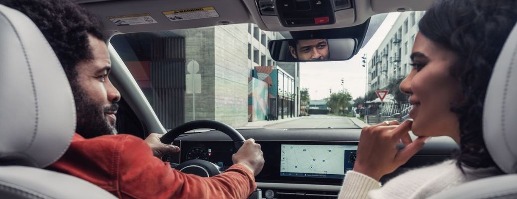 A couple driving a Hyundai vehicle and smiling