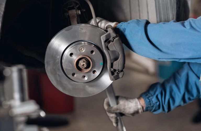 Technician checking brake plate of a vehicle