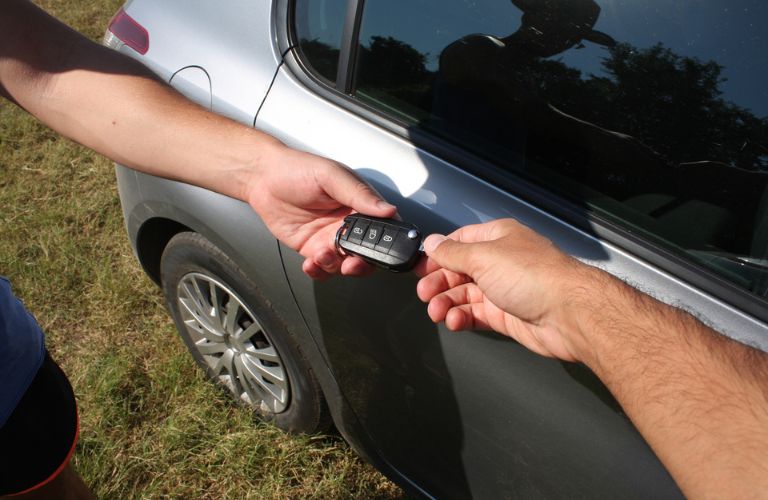 A dealer exchanging the car key to a customer