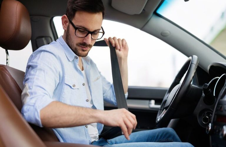 a young man wearing seat belt in a car
