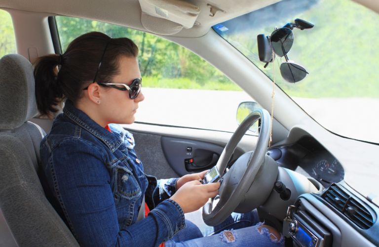 a teen girl texting while driving