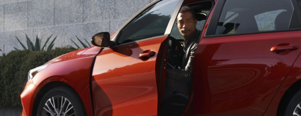 a man getting out of a Kia