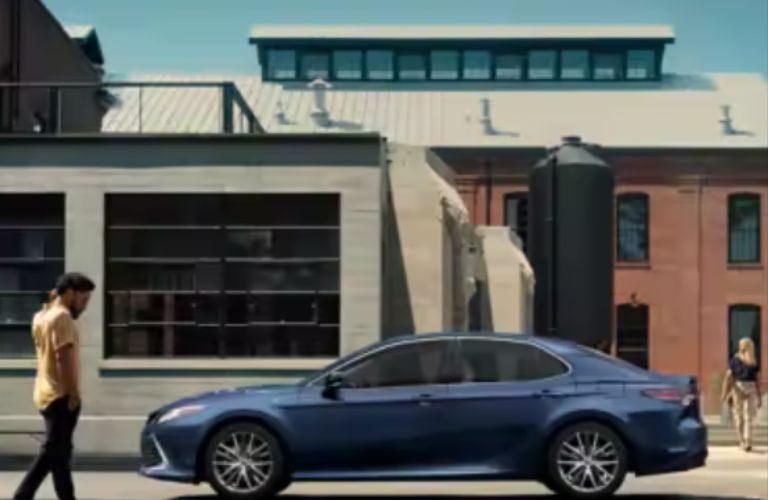 a man walking towards a Kia