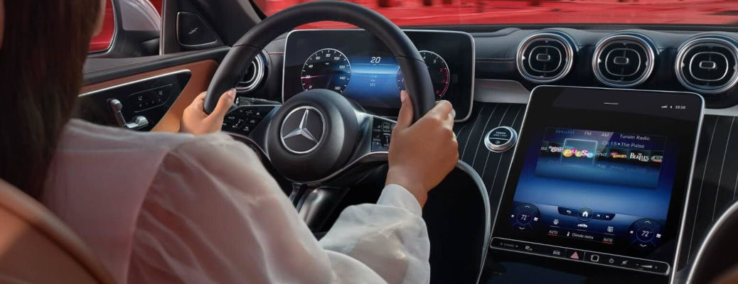 A woman driving a Mercedes C class.