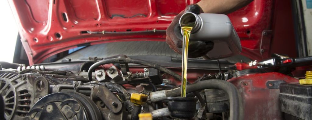 a technician pouring engine oil