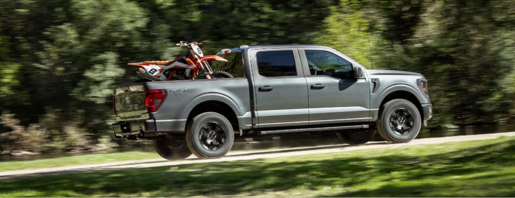 2024 Ford F-150 STX hauling bikes on a road