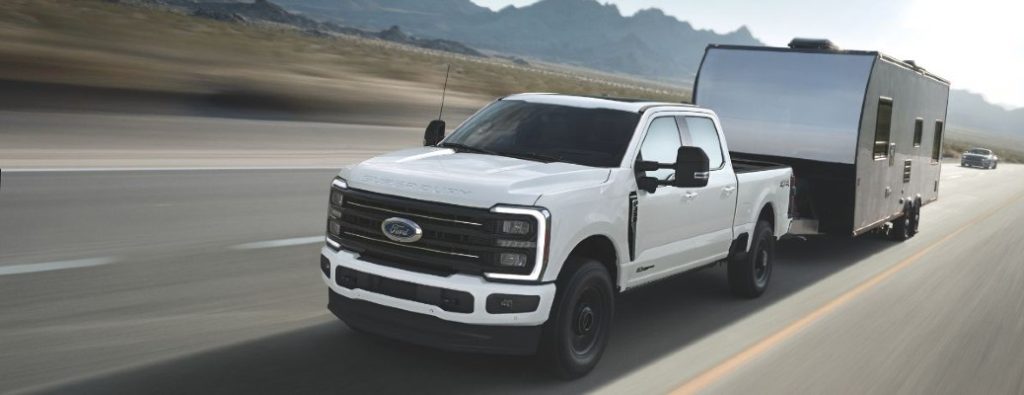 2025 Ford Super Duty in white towing a trailer