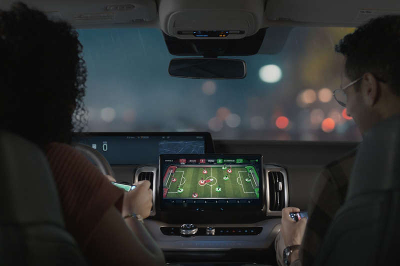 A man playing a game in a Ford vehicle utilizing the car's infotainment system