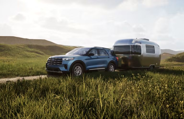 2025 Ford Explorer towing a trailer through a field