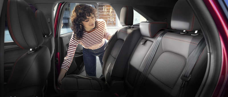 A woman examining the back seat in the 2025 Ford Escape