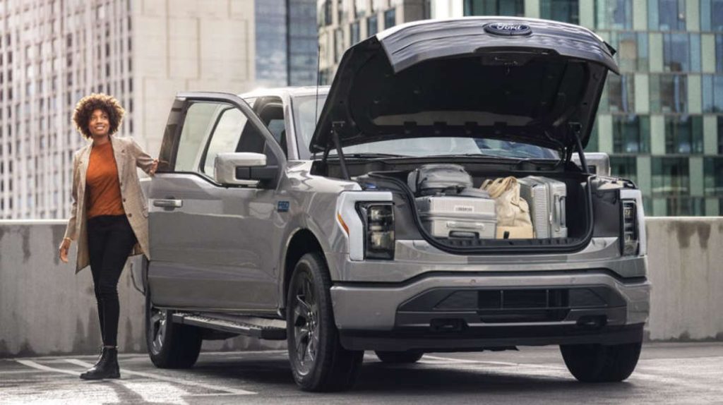 A woman making use of the Ford Mega Power Frunk